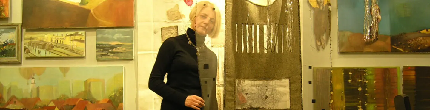 Fotografia przedstawiająca artystkę, Elżbietę Grzybek, pośród swoich dzieł.